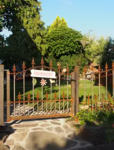 Schmiedeeiserne Gartentür Lucca in Edelrost mit Spitze Kreuzlilie